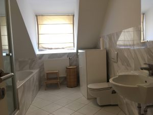 Bathroom with tub and rain shower in Munich
