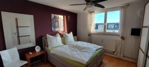 Large bedroom with comfortable box-spring bed in furnished flat in Munich