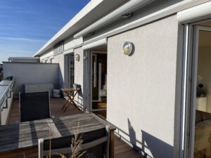 Spacious roof terrace with wooden floorboards and electric sun blinds in furnished flat in Munich West